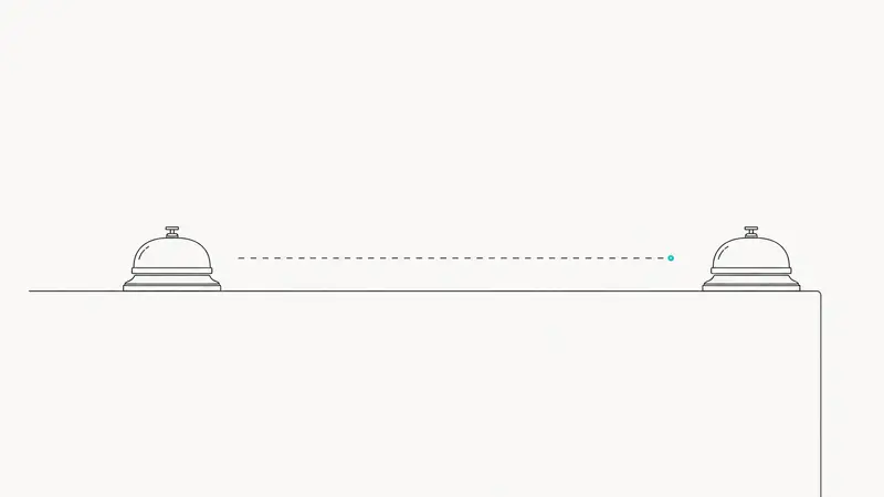 Two identical desk call bells on a counter, with a dashed line measuring the distance between them