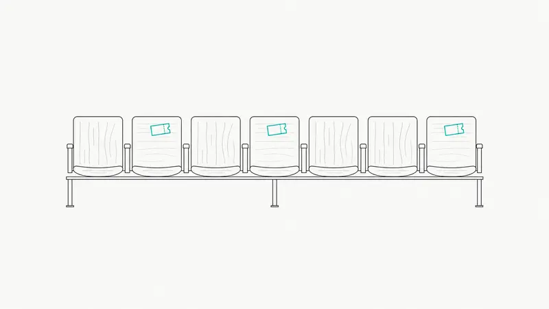 A row of eight chairs with a paper ticket resting on only three of them